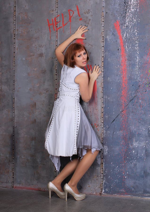 Beautiful legged redhead photomodel  in gray dress and  shiny pantyhose  posing at the walll. Long legs pretty smyle incredible body, white stockings. Beautiful legged redhead photomodel  in gray dress and  shiny pantyhose  posing at the walll. Long legs pretty smyle incredible body, white stockings.