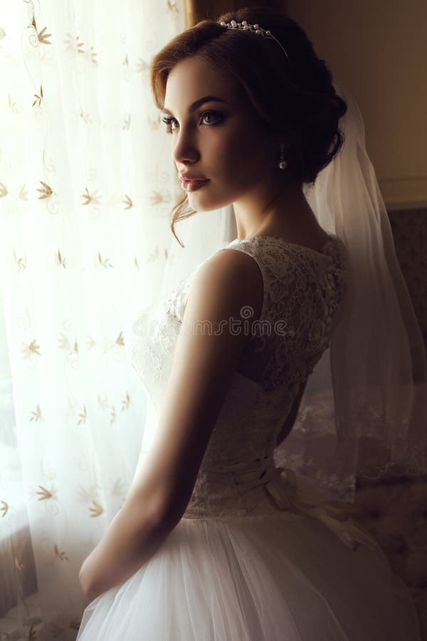 Mooie sensuele bruid met donker haar in de luxueuze kleding van het kanthuwelijk royalty-vrije stock foto Mooie sensuele bruid met donker haar in de luxueuze kleding van het kanthuwelijk royalty-vrije stock foto