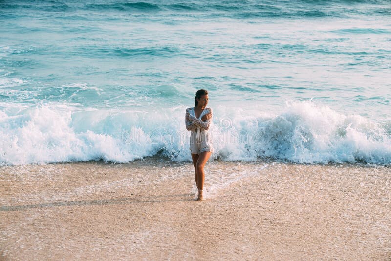 Mooie sexy slank, suntanned meisje in een witte strandkleding bevindt zich nat op het strand, tegen de achtergrond van stock foto's Mooie sexy slank, suntanned meisje in een witte strandkleding bevindt zich nat op het strand, tegen de achtergrond van stock foto's