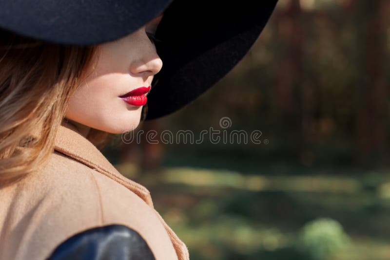 Mooie sexy vrouw in elegante zwarte hoed met grote gebieden en heldere rode lippenstift op haar lippen stock fotografie Mooie sexy vrouw in elegante zwarte hoed met grote gebieden en heldere rode lippenstift op haar lippen stock fotografie