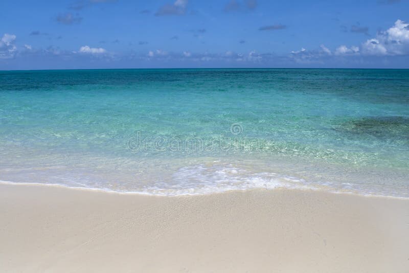 Beautiful tropical shoreline with clear green water and wave rolling up on white sandy shore. Beautiful tropical shoreline with clear green water and wave rolling up on white sandy shore.