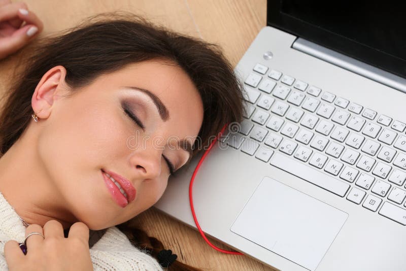 Mooie vrouw die op laptop computer op houten vloer liggen sleepin stock foto Mooie vrouw die op laptop computer op houten vloer liggen sleepin stock foto
