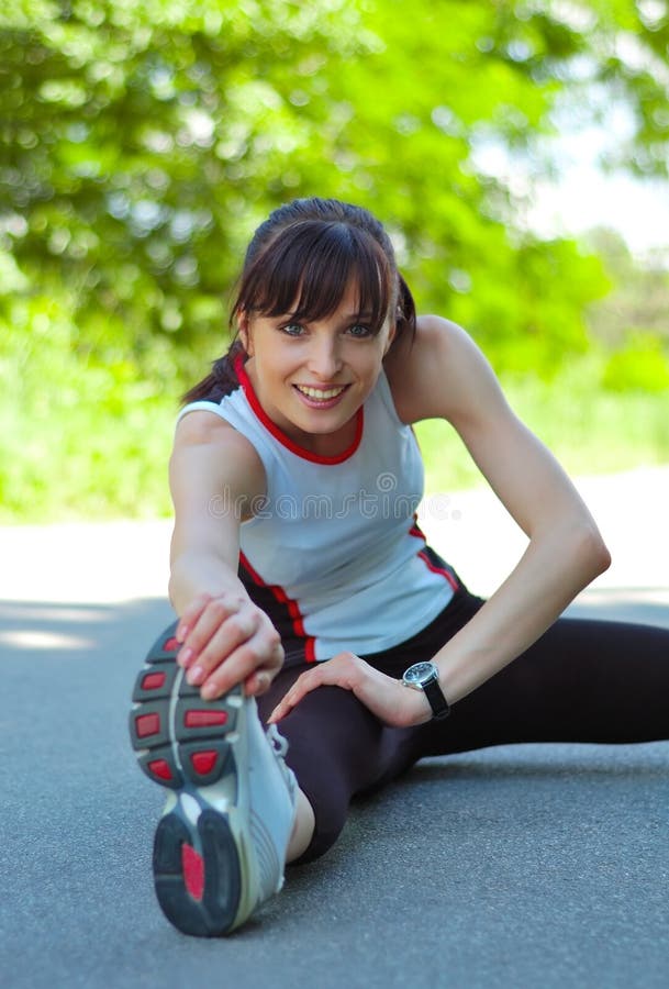 Beautiful Young Woman Doing Stretching Exercise in the Park. Beautiful Young Woman Doing Stretching Exercise in the Park