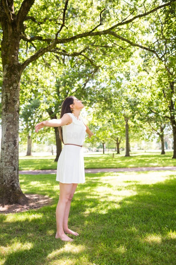 Mooie vrouw die zich op gras in park bevinden royalty-vrije stock afbeelding Mooie vrouw die zich op gras in park bevinden royalty-vrije stock afbeelding