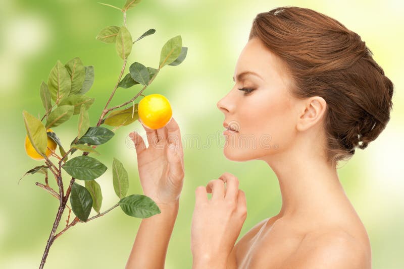 Prachtige vrouw met een takje citroen stock fotografie