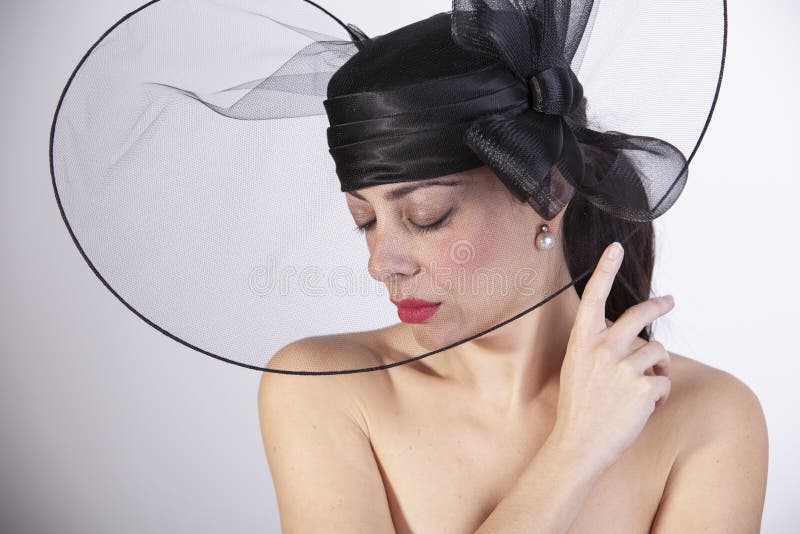 Mooie vrouw met rode lippen, en gesloten ogen met droevige blik en zwarte hoed Retro manier royalty-vrije stock afbeelding Mooie vrouw met rode lippen, en gesloten ogen met droevige blik en zwarte hoed Retro manier royalty-vrije stock afbeelding