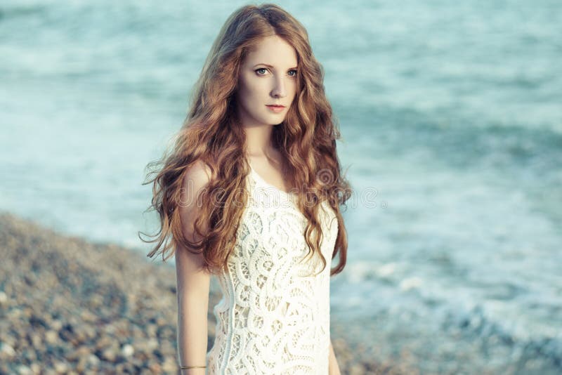 Mooie vrouw met rood haar aan zee royalty-vrije stock foto's