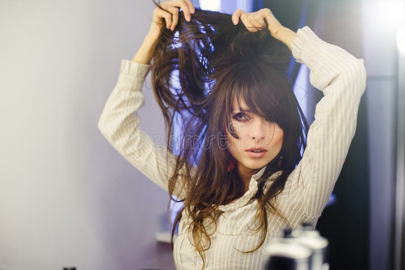 Mooie vrouw voor de spiegel die haar doen royalty-vrije stock fotografie Mooie vrouw voor de spiegel die haar doen royalty-vrije stock fotografie