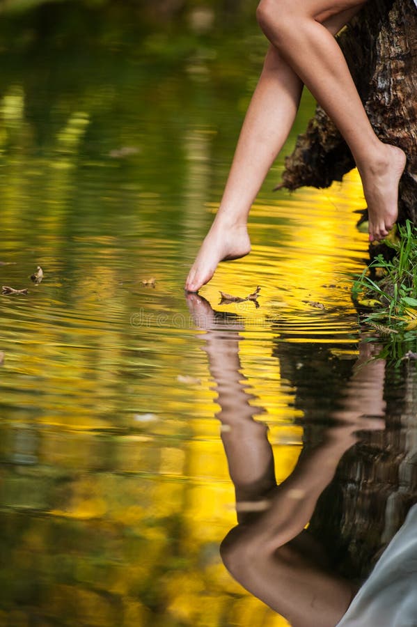 Mooie vrouwenbenen in water in het bos. sprookje