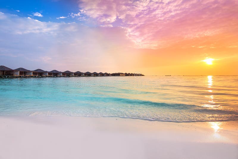 Mooie zonsondergang bij tropische toevlucht met overwaterbungalowwen royalty-vrije stock afbeeldingen Mooie zonsondergang bij tropische toevlucht met overwaterbungalowwen royalty-vrije stock afbeeldingen