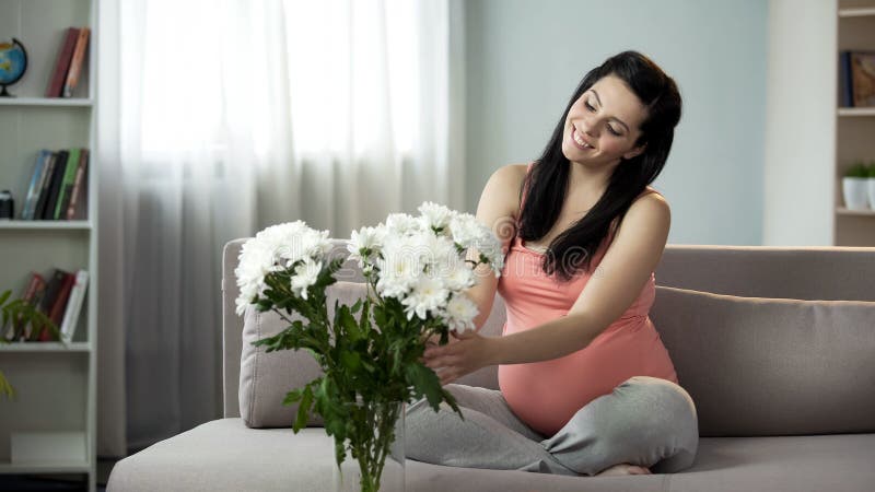 Mooie zwangere dame die huis met aardige bloemen verfraaien, esthetisch plezier stock foto's Mooie zwangere dame die huis met aardige bloemen verfraaien, esthetisch plezier stock foto's