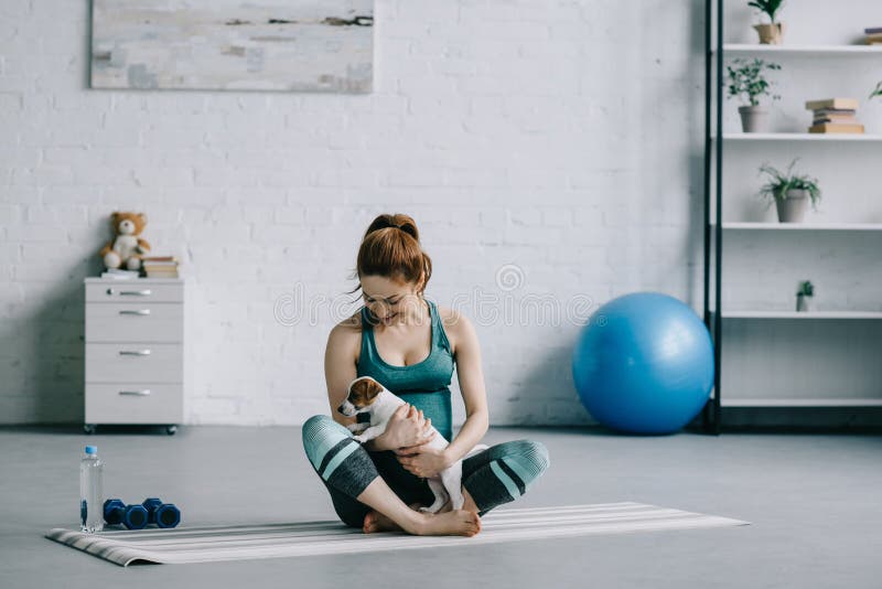 mooie zwangere vrouwenzitting op yogamat met hefboom Russell stock fotografie mooie zwangere vrouwenzitting op yogamat met hefboom Russell stock fotografie