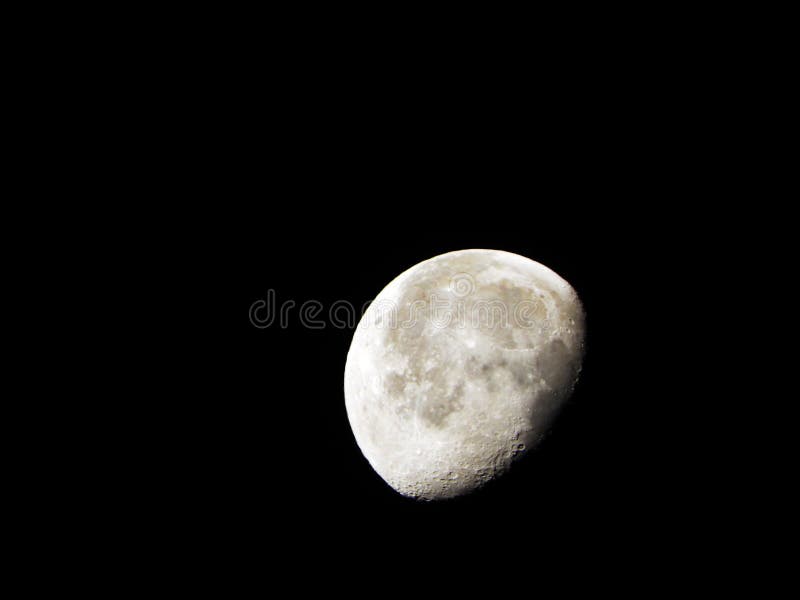 Waning Gibbous Moon in the black night sky less than full but more than half-lighted royalty free stock image.