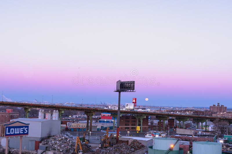 The Moon sets behind the elevated portion of the Brooklyn Queens Expressway stock photo