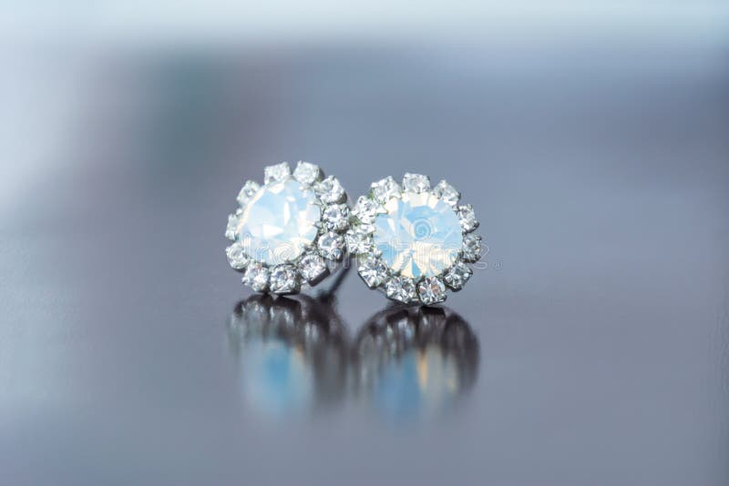 Moonstone stud earrings with reflection on the dark background