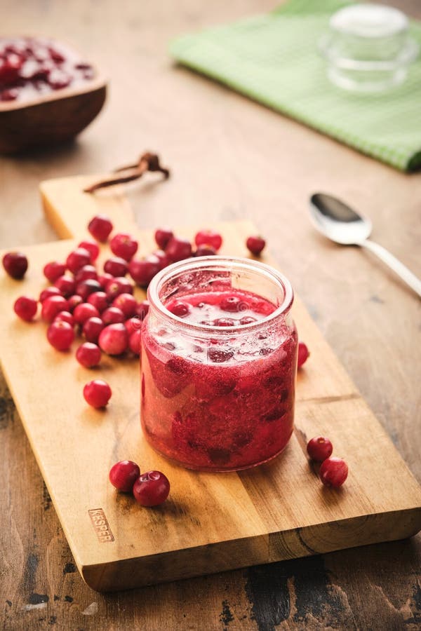 Moosbeermarmelade in einem Glasgefäß auf einem hölzernen Verwaltungsrat stockfotos