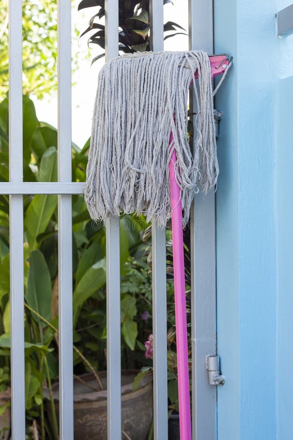 Mop Head is Leaning Against the Wall after Cleaning in the Laundry Room