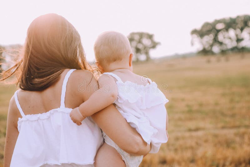 Mor, liten dotter, vit klänningsfältsugga fotografering för bildbyråer
