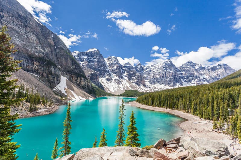 Beautiful Moraine lake in Banff National Park, Canadian Rockies, Canada. Sunny summer day with amazing blue sky. Majestic mountains in the background. Clear turquoise blue water. Hiker`s dream. Beautiful Moraine lake in Banff National Park, Canadian Rockies, Canada. Sunny summer day with amazing blue sky. Majestic mountains in the background. Clear turquoise blue water. Hiker`s dream.