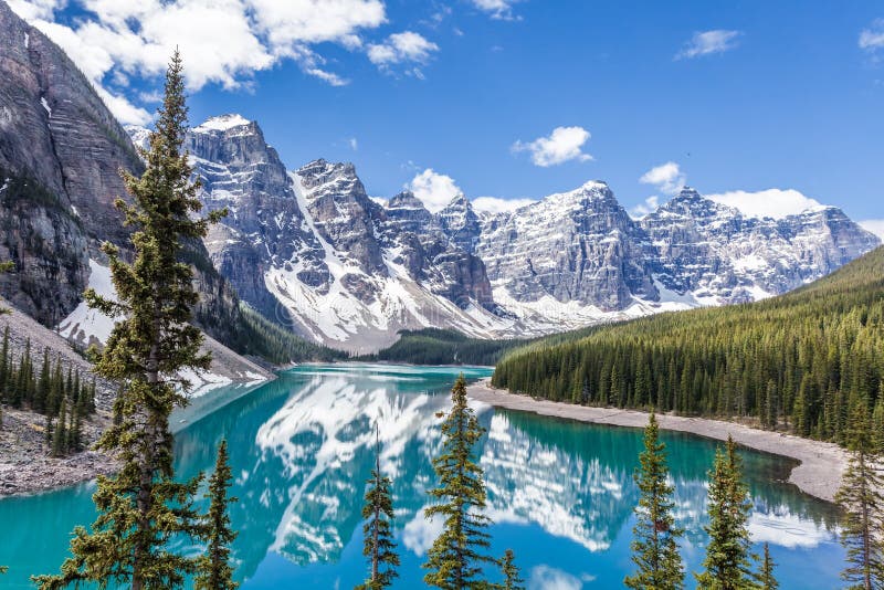 Beautiful Moraine lake in Banff National Park, Canadian Rockies, Canada. Sunny summer day with amazing blue sky. Majestic mountains in the background. Clear turquoise blue water. Hiker`s dream. Beautiful Moraine lake in Banff National Park, Canadian Rockies, Canada. Sunny summer day with amazing blue sky. Majestic mountains in the background. Clear turquoise blue water. Hiker`s dream.