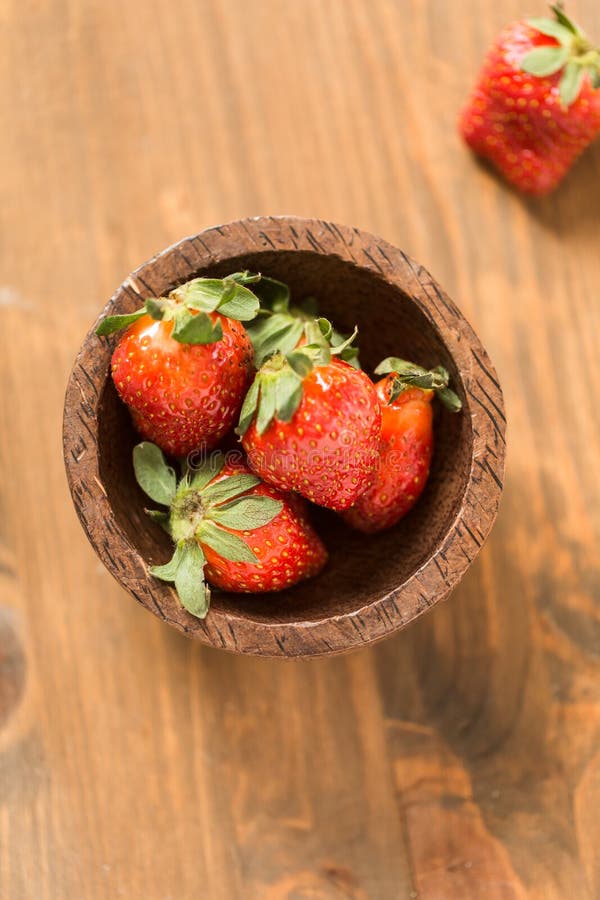Morangos na bacia de madeira imagens de stock