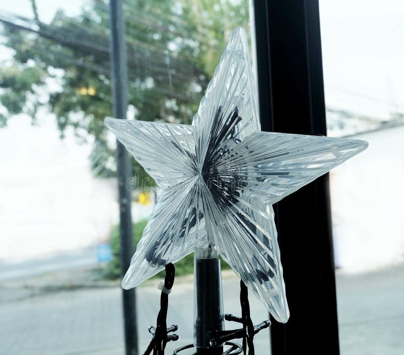 Glass Moravian Star and Tiny Christmas Lights in A House, Sign for Christmas Celebration. Glass Moravian Star and Tiny Christmas Lights in A House, Sign for Christmas Celebration