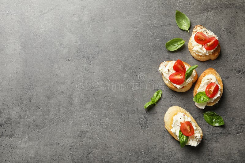 Morceaux de baguette avec le fromage fondu et les tomates savoureux sur la table grise, configuration plate images libres de droits Morceaux de baguette avec le fromage fondu et les tomates savoureux sur la table grise, configuration plate images libres de droits