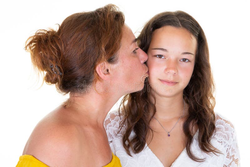 Mordente adulto do beijo da mãe das mulheres bonitas caucasianos sua posição da menina da filha adolescente isolada sobre o fundo imagens de stock royalty free Mordente adulto do beijo da mãe das mulheres bonitas caucasianos sua posição da menina da filha adolescente isolada sobre o fundo imagens de stock royalty free
