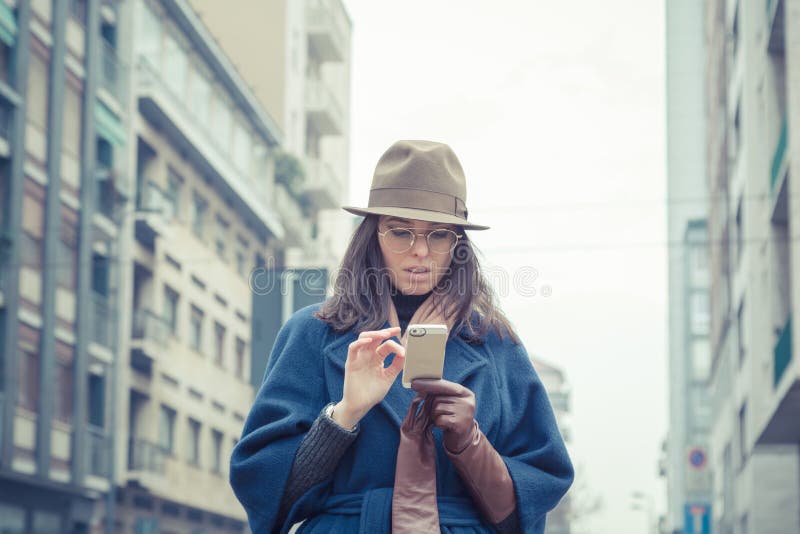 Jovem morena bonita a enviar mensagens nas ruas da cidade fotografia de stock