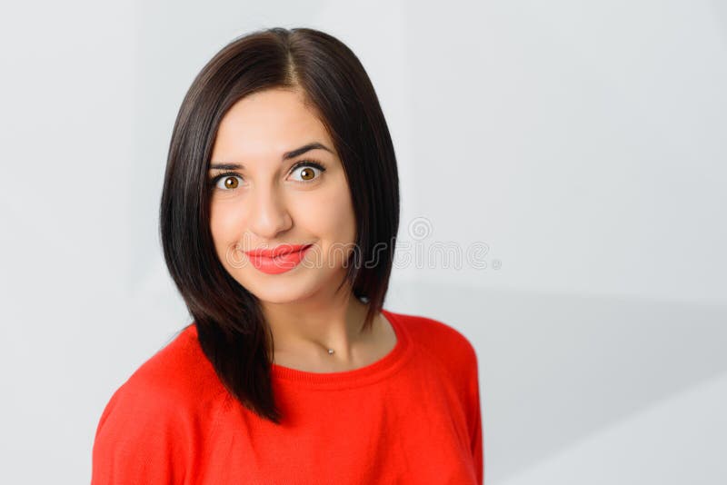 A morena surpreendeu o vermelho vestindo surpreendido da jovem mulher alegre foto de stock royalty free A morena surpreendeu o vermelho vestindo surpreendido da jovem mulher alegre foto de stock royalty free