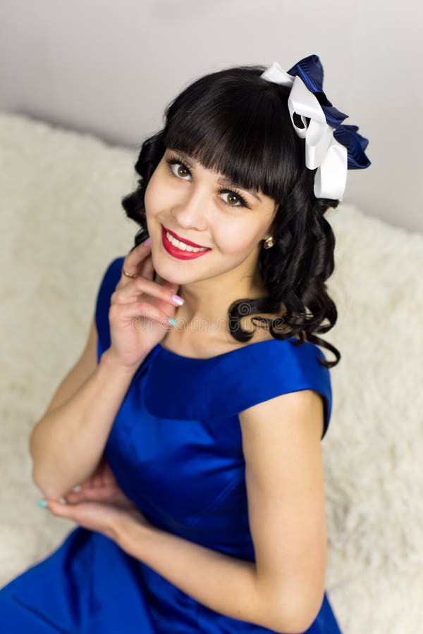Morenita de la muchacha en un vestido azul en un fondo blanco fotografía de archivo Morenita de la muchacha en un vestido azul en un fondo blanco fotografía de archivo
