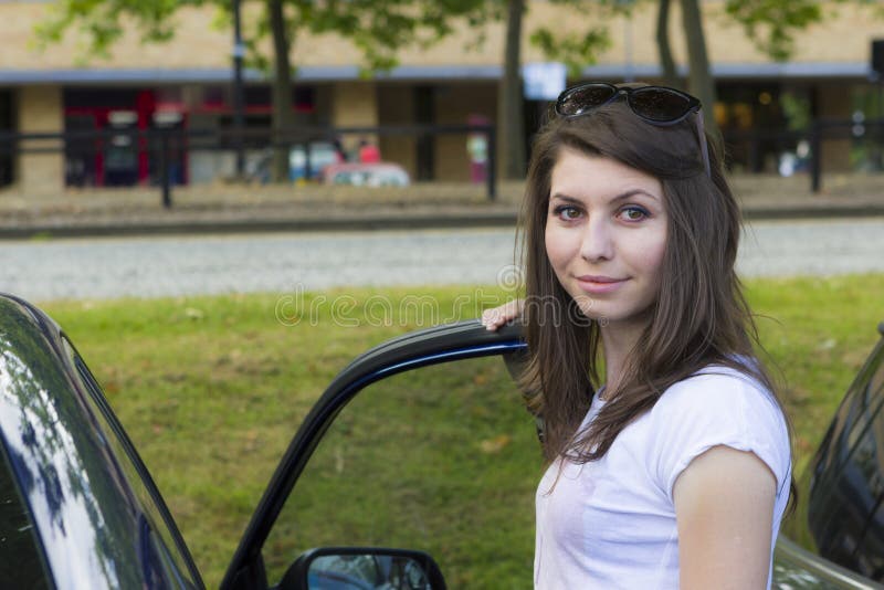 Morenita joven que presenta cerca del coche fotos de archivo Morenita joven que presenta cerca del coche fotos de archivo