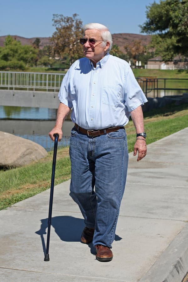 Grandpa, age 84, uses a cane to assist him with walking. He is getting some exercise at the park. He is wearing sunglasses. Grandpa, age 84, uses a cane to assist him with walking. He is getting some exercise at the park. He is wearing sunglasses.