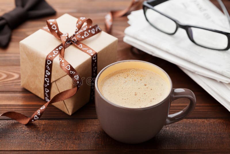 Morgen Tasse Kaffee, Geschenk, Zeitung, Gläser und bowtie auf hölzernem Schreibtisch zum Frühstück am glücklichen Vatertag stockbilder Morgen Tasse Kaffee, Geschenk, Zeitung, Gläser und bowtie auf hölzernem Schreibtisch zum Frühstück am glücklichen Vatertag stockbilder
