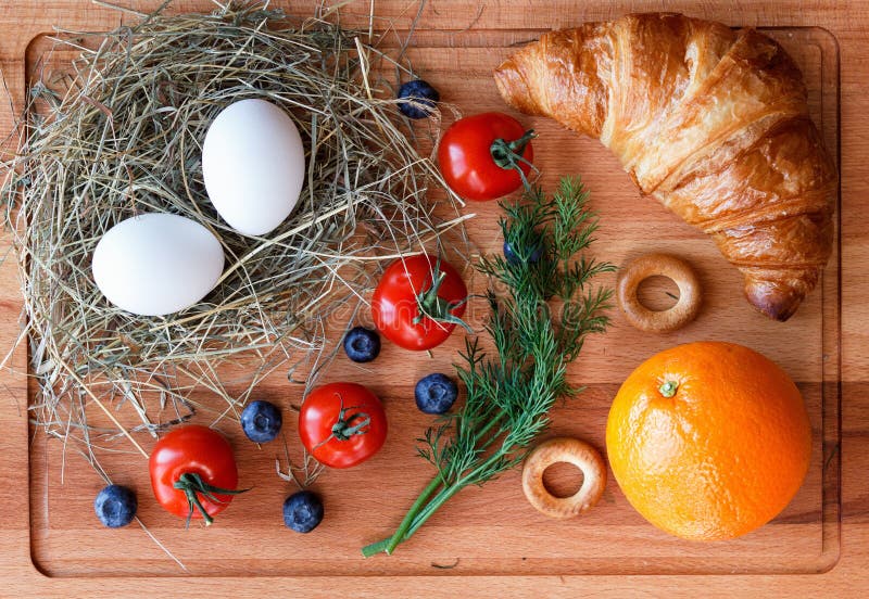 Morgenmahlzeit mit einer Orange, Eiern und einem Hörnchen stockfotos Morgenmahlzeit mit einer Orange, Eiern und einem Hörnchen stockfotos