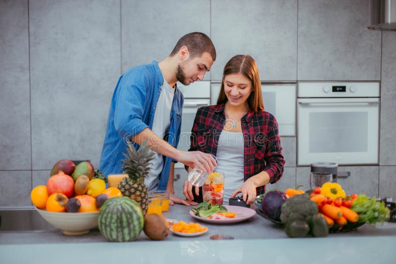 Morgens ein charismatisches Paar der modernen Küche, das einen frischen Smoothie zum das Frühstück macht stockbilder Morgens ein charismatisches Paar der modernen Küche, das einen frischen Smoothie zum das Frühstück macht stockbilder