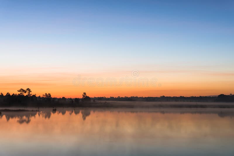 Morgensonnenaufgang über dem See mit Schattenbildbaum denken über Wasseroberfläche bei Phu Kradueng, Nationalpark in Thailand nac lizenzfreie stockfotos Morgensonnenaufgang über dem See mit Schattenbildbaum denken über Wasseroberfläche bei Phu Kradueng, Nationalpark in Thailand nac lizenzfreie stockfotos