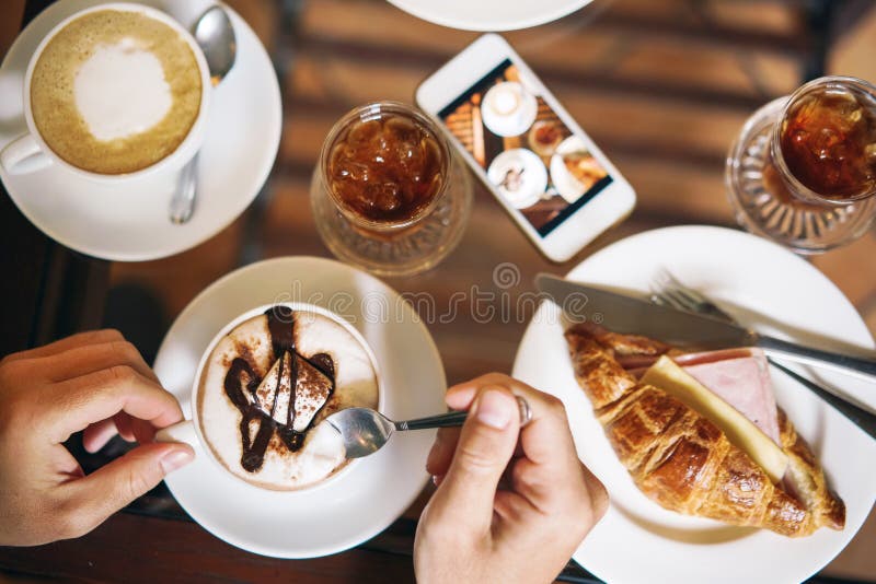 Morgonfrukost för två: en giffel med skinka, kaffe, en uppfriskande drink Mannen räcker att rymma en kopp kaffe fotografering för bildbyråer Morgonfrukost för två: en giffel med skinka, kaffe, en uppfriskande drink Mannen räcker att rymma en kopp kaffe fotografering för bildbyråer