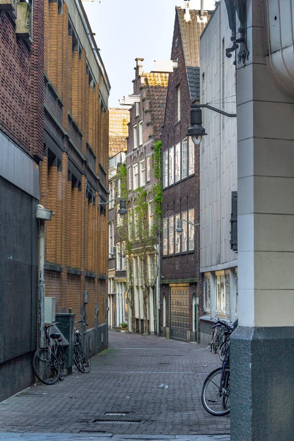 AMSTERDAM, NETHERLANDS - MAY 6, 2013: This is one of the small lanes in the city center deserted in the early morning. AMSTERDAM, NETHERLANDS - MAY 6, 2013: This is one of the small lanes in the city center deserted in the early morning