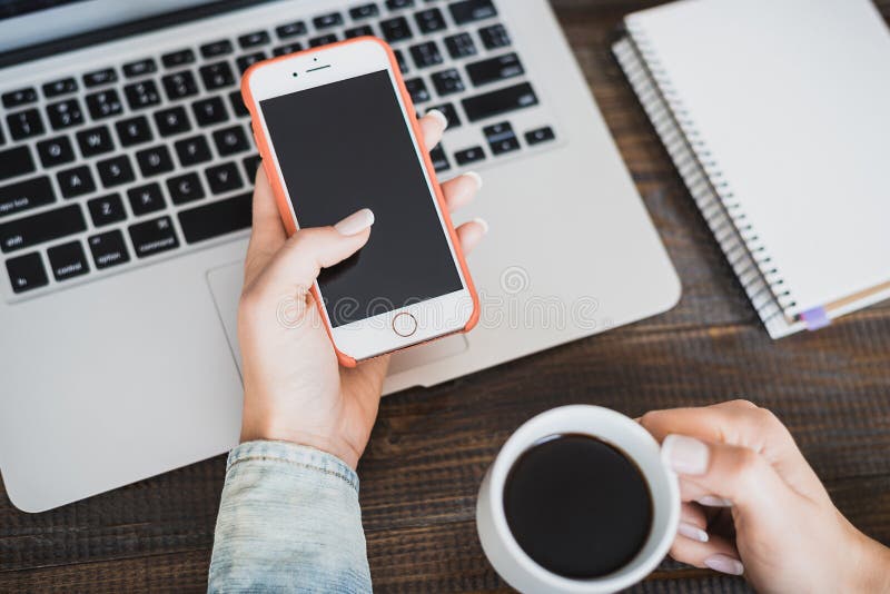 Morning business woman. Laptop on the desk, phone and a cup of coffee in female hands. Horizontal frame stock photo Morning business woman. Laptop on the desk, phone and a cup of coffee in female hands. Horizontal frame stock photo
