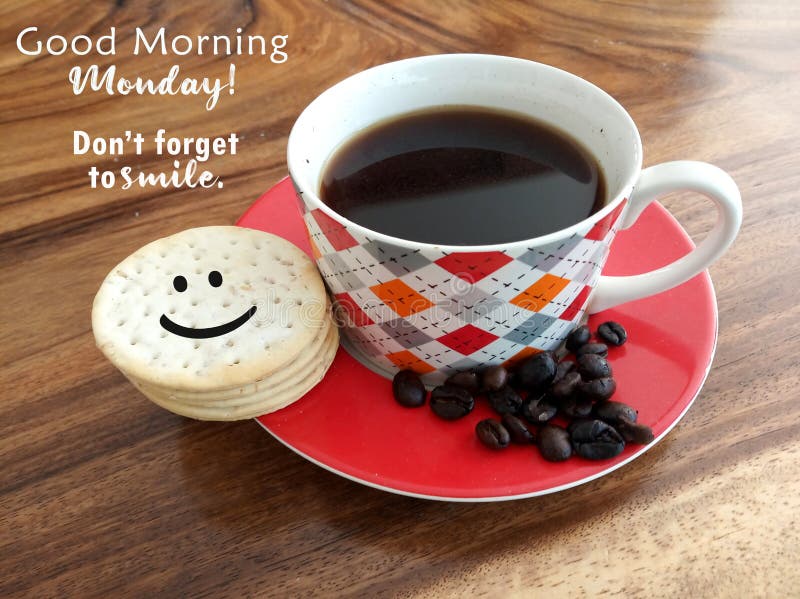 Morning coffee. Cup of black coffee and raw coffee beans with smiling face on cookies and text greeting - Good morning Monday. Do not forget to smile. On natural background of wooden table. Morning coffee. Cup of black coffee and raw coffee beans with smiling face on cookies and text greeting - Good morning Monday. Do not forget to smile. On natural background of wooden table