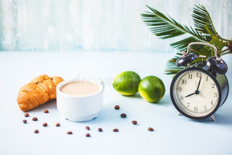 Morning coffee in a white cup Croissant Lime on a light background Wake-up with an alarm clock Breakfast cheerfulness, a healthy b stock photography Morning coffee in a white cup Croissant Lime on a light background Wake-up with an alarm clock Breakfast cheerfulness, a healthy b stock photography