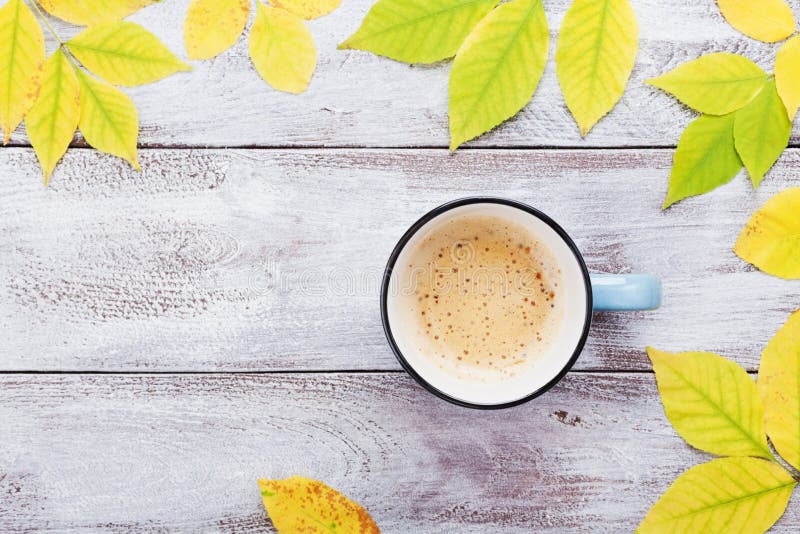 Morning cup of coffee and autumn leaves on vintage wooden table top view. Cozy breakfast. Flat lay style. stock images Morning cup of coffee and autumn leaves on vintage wooden table top view. Cozy breakfast. Flat lay style. stock images