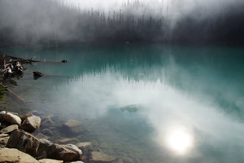 Morning mist rising from turquoise lake