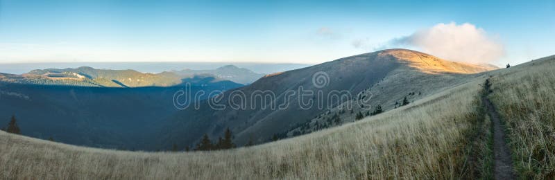 Morning on mountain ridge under blue sky in late summer