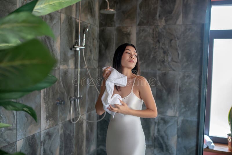 Brunette Female Standing In Shower In Night Dress Wiping With Towel