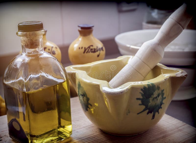 Mortaio ceramico tradizionale accanto ad una bottiglia di olio d'oliva in una cucina immagine stock Mortaio ceramico tradizionale accanto ad una bottiglia di olio d'oliva in una cucina immagine stock
