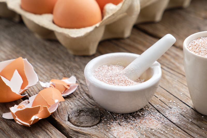 Mortar of crushed eggshell, cardboard box of eggs. Whole and powdered eggshells, natural calcium.