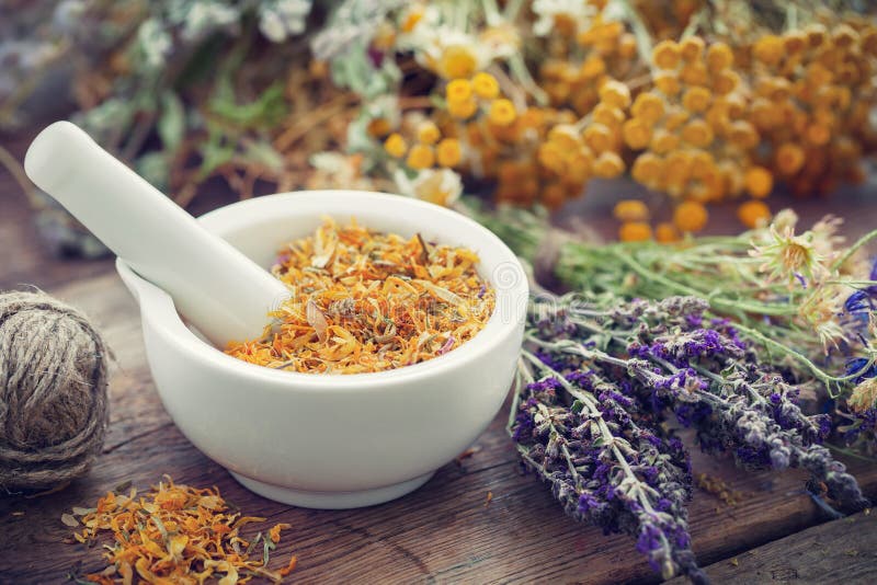 Mortar of dried marigold flowers and healing herbs.