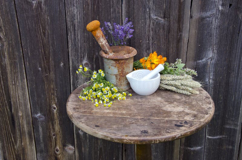 Mortars on old table and various medical herbal medicine flowers